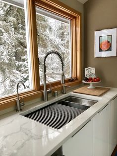 a kitchen sink under a window next to a counter