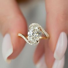 a woman's hand holding a diamond ring