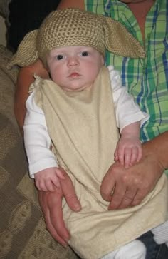 a woman holding a baby wearing a bib on her lap while she holds it