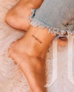 a woman's foot with the word fearless tattooed on her left side and an inscription below it