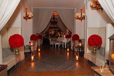 a room filled with lots of white furniture and red flowers