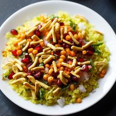 a white plate topped with rice and beans on top of a black table next to a fork