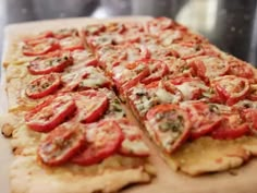 a pizza with tomatoes and cheese cut into slices