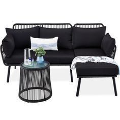 a black couch and ottoman with pillows on it