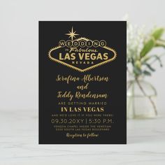 a black and gold wedding card with the las vegas sign on it's side