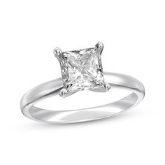 a white gold ring with a princess cut diamond in the center, on a white background