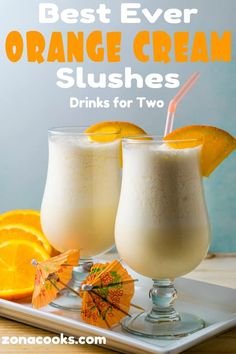 two glasses filled with orange cream slushes on top of a white platter