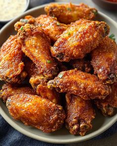 fried chicken wings on a plate with dipping sauce