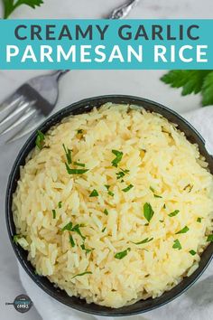 creamy garlic parmesan rice in a black bowl on a white cloth with a fork