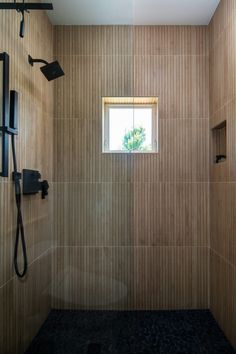 a bathroom with tiled walls and a window above the shower head is seen in this image