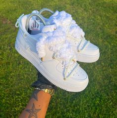 This is a white AF1 with gold accents, fluffy shoelaces and the OW cross lace. Luxury White Custom Sneakers With Elastic Laces, White Sneakers With Round Toe And Lacing, White Sneakers With Lacing And Round Toe, White Round Toe Sneakers With Lacing, White Sneakers With Lacing For Streetwear, White Sneakers For Streetwear With Lacing, White Lacing Sneakers For Streetwear, White Custom Sneakers, Shoes With Rope Laces