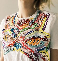 a woman wearing a t - shirt with colorful designs on it