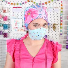 a woman wearing a surgical mask and pink top