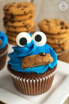 cookie monster cupcakes with blue frosting and googly eyes on white plate