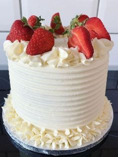 a cake with white frosting and strawberries on top