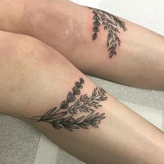 two women with tattoos on their legs are sitting next to each other and one has a flower tattoo on her leg