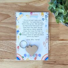 a card with a heart shaped keychain on top of it next to a potted plant