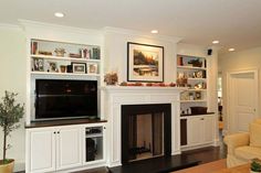 a living room filled with furniture and a flat screen tv mounted on a wall above a fire place