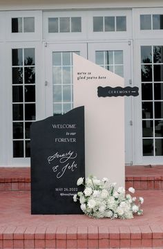 a welcome sign and flowers are on the steps