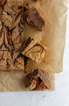 some brownies are cut into squares and placed on top of parchment paper with chocolate chips