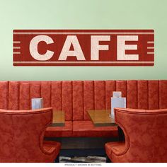 a restaurant with red booth seats and a cafe sign on the wall