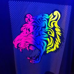 a neon colored tiger sticker on the side of a computer screen in a dark room