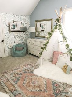 a bedroom with a teepee tent in the corner and rugs on the floor