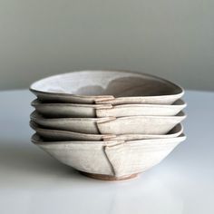 four white bowls stacked on top of each other