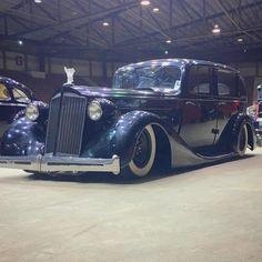 an old black car parked in a garage