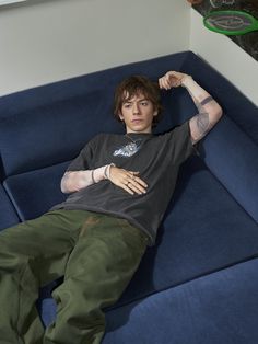 a man laying on top of a blue couch