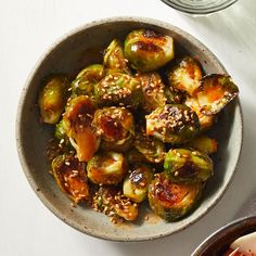 a bowl filled with cooked brussel sprouts and sesame seeds