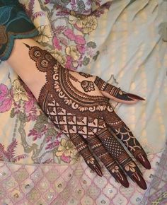 a henna on someone's hand with flowers all over it