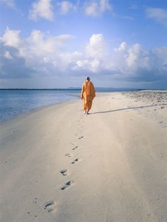 a person walking on the beach with footprints in the sand