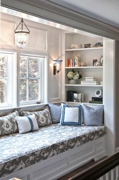 a living room filled with lots of furniture and bookshelves next to a window