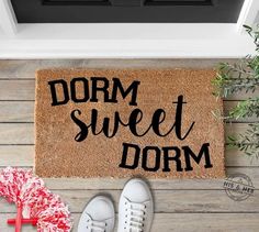 a door mat with the words dorm sweet dorm on it next to shoes and an umbrella