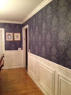 an empty room with blue wallpaper and white trim on the walls is pictured in this image