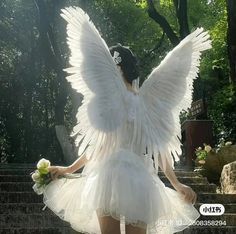 a woman dressed as an angel standing on some steps