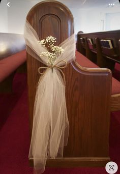 a church pew decorated with baby's breath flowers and organe bow for the aisle