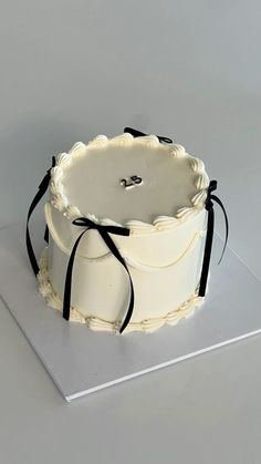 a white cake with black ribbon on top