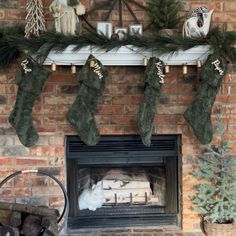 a fireplace decorated for christmas with stockings hanging from the mantel