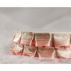 a close up of a pink ribbon on a white cloth with some folds in it