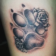 a black and white photo of a dog paw with roses on it's side