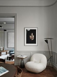 a living room with a chair, table and pictures on the wall