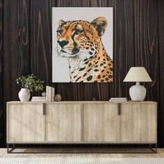 a painting of a cheetah on a wall next to a sideboard with a lamp