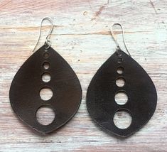 two black leather earrings with holes in the middle