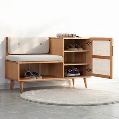 a wooden cabinet with shoes on it next to a rug