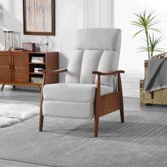 a white recliner chair sitting on top of a rug in front of a wooden cabinet