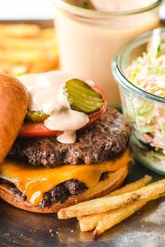 a cheeseburger with pickles, tomatoes and dressing