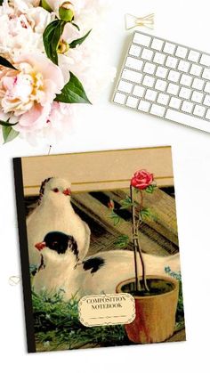 a computer keyboard sitting on top of a desk next to a card with a flower