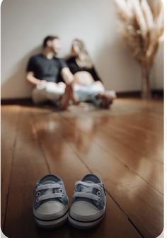 two people sitting on the floor next to each other with their feet propped up in front of them